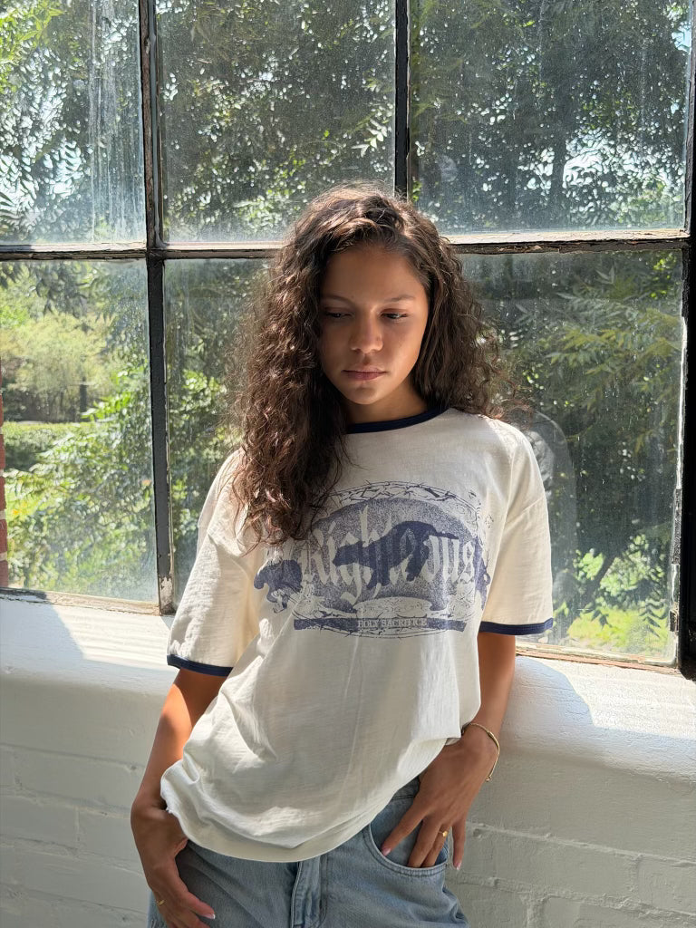 We Are Righteous Holy Sacrifice Ringer Tee worn by a model in front of a sunlit window