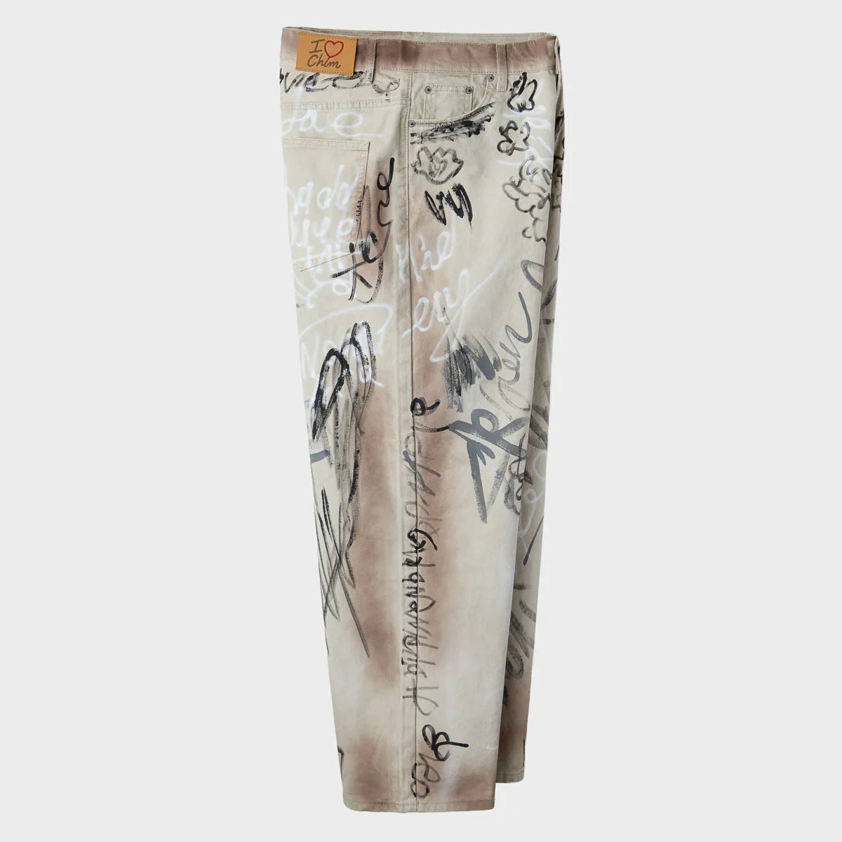 Side view of the wide-leg ecru graffiti trousers showing the full leg drape