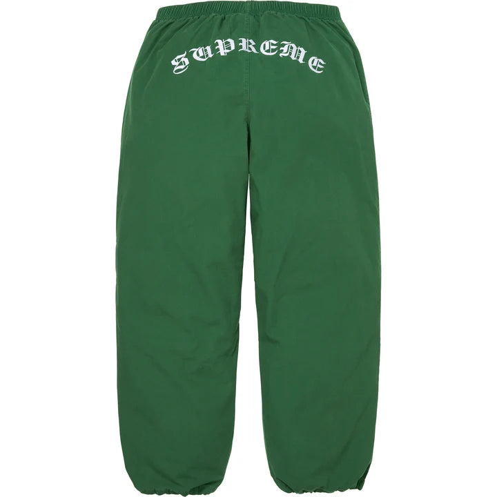 Back of the green Supreme x Umbro track pants with arched gothic Supreme embroidery below the waistband