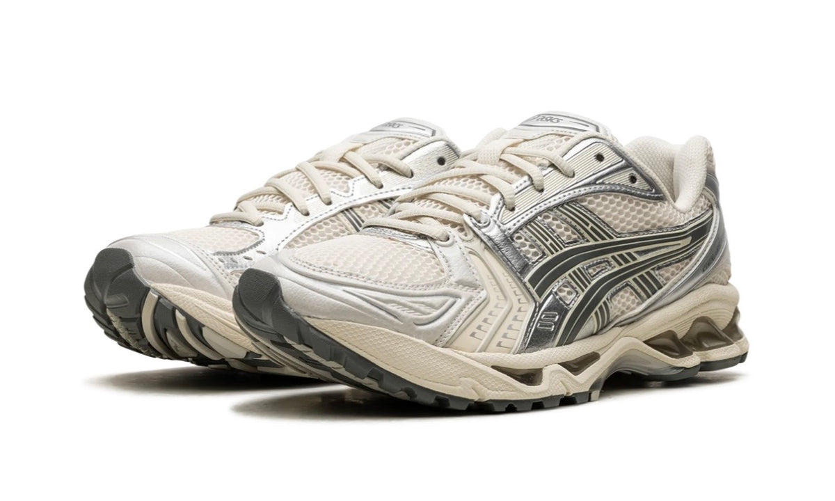 Pair of Asics Gel-Kayano 14 Birch Dark Pewter from the front, cream laces and layered silver overlays
