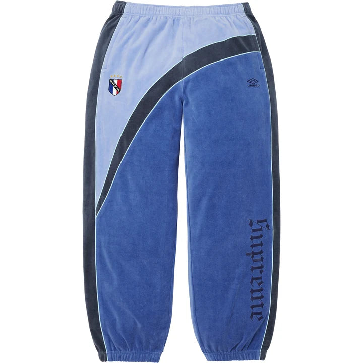 Supreme x Umbro Blue Velour Track Pants front view with pale blue panelling and blackletter leg lettering