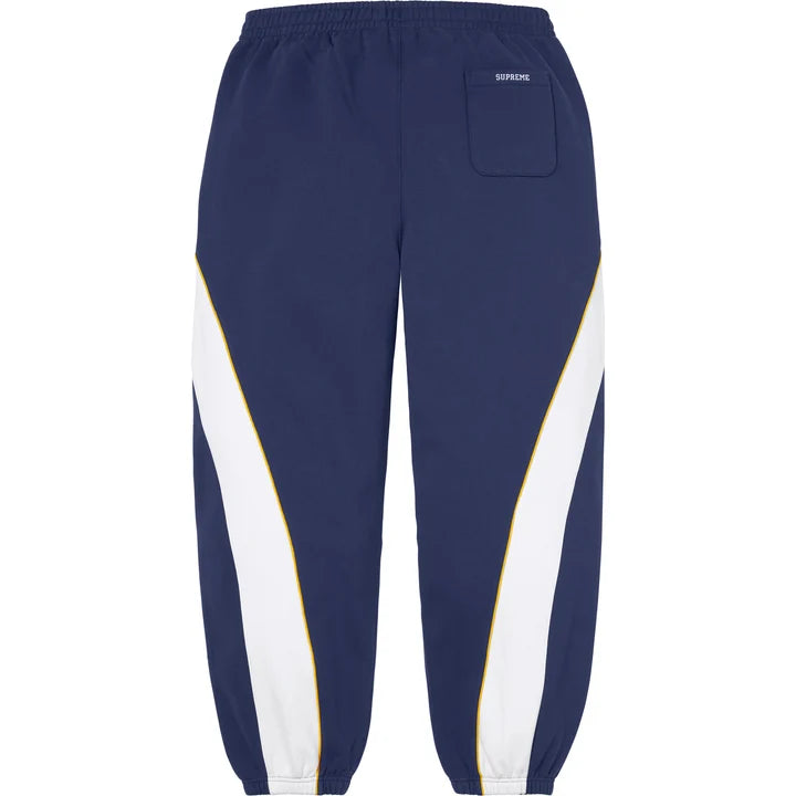 Back of the navy Supreme x Nike paneled sweatpants with a back pocket and gold-piped white panels