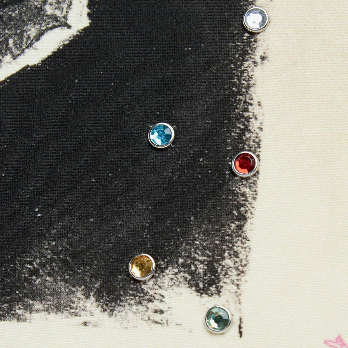 HMDD Sketch Hoodie, macro of the black printed panel set with small coloured rhinestone studs in blue, red, gold and teal