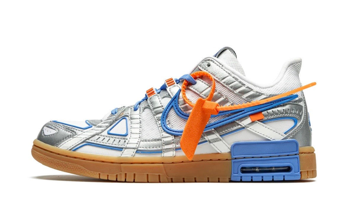 Off-White x Nike Air Rubber Dunk UNC in white, metallic silver and university blue on a gum sole with an orange zip tie, lateral side view