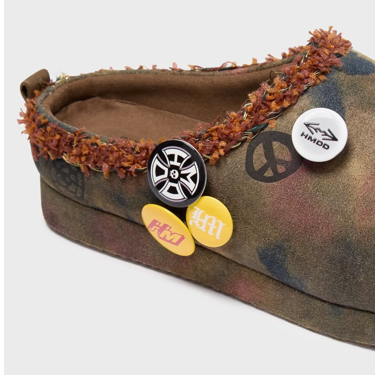 HMDD Graffiti Mule, close-up of the collar with orange shearling trim, a wheel pin, a peace sign pin and yellow badges