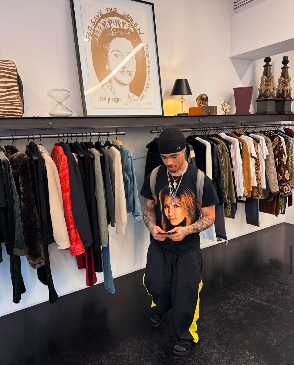 Model wearing the Stile De Amor black skull cap with a graphic tee in a clothing boutique