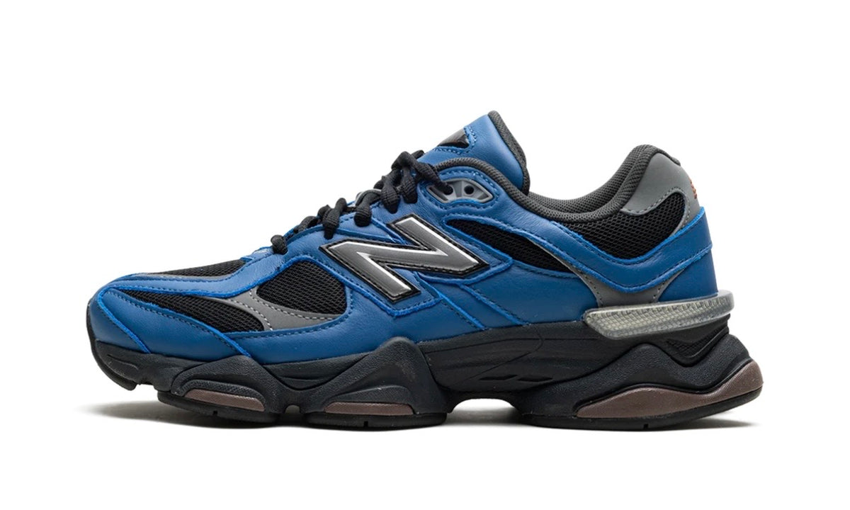 New Balance 9060 Dark Royal Brown, lateral side of the 9060 with royal blue overlays, black mesh, a grey N logo and silver heel accent on a black sculpted sole