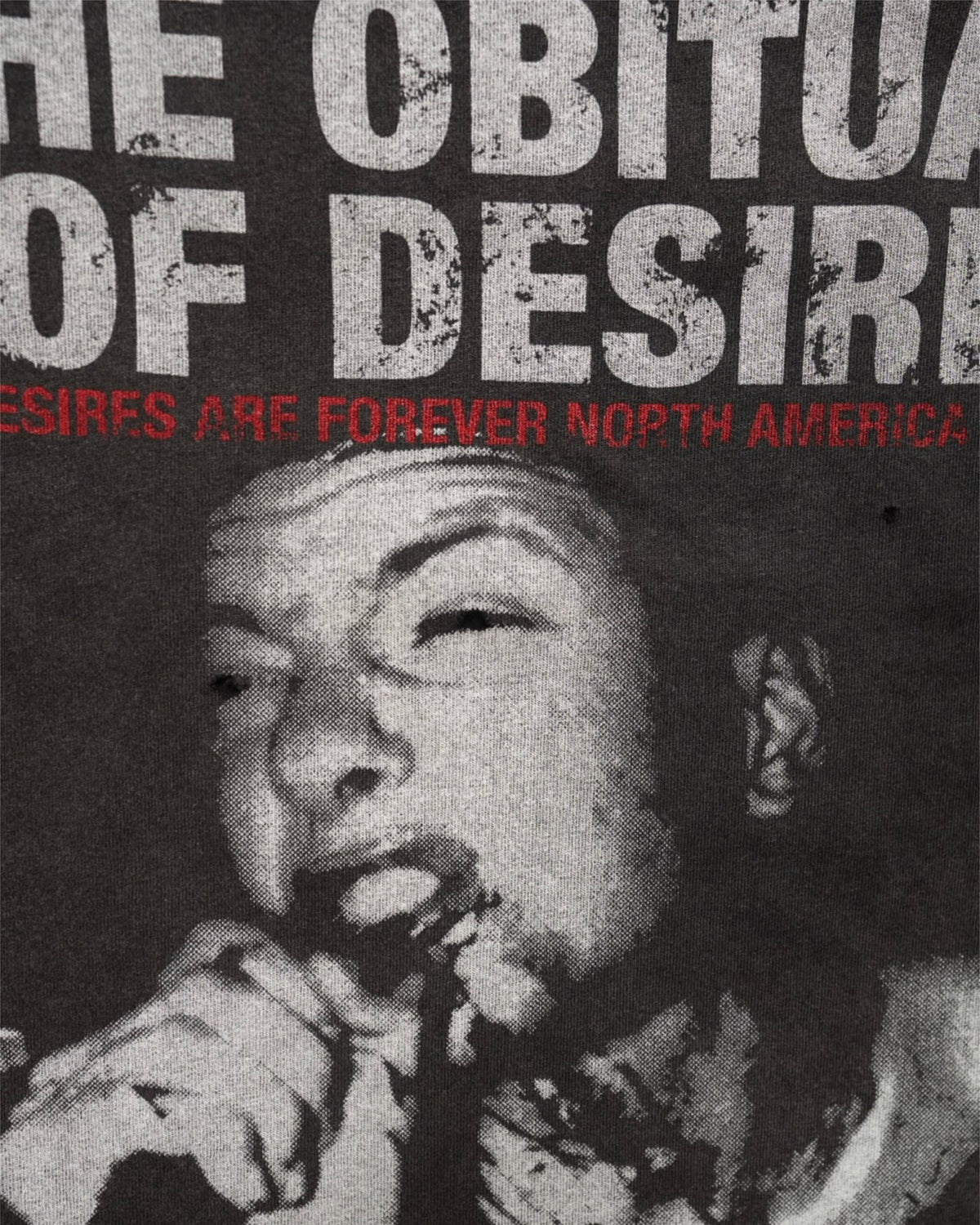 Close-up of the Obituary tee front photo print and red subtitle line