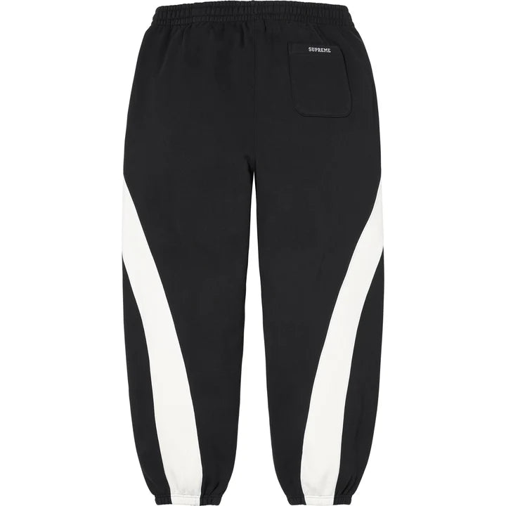 Back of the black Supreme x Nike paneled sweatpants with a back pocket and curved white panels
