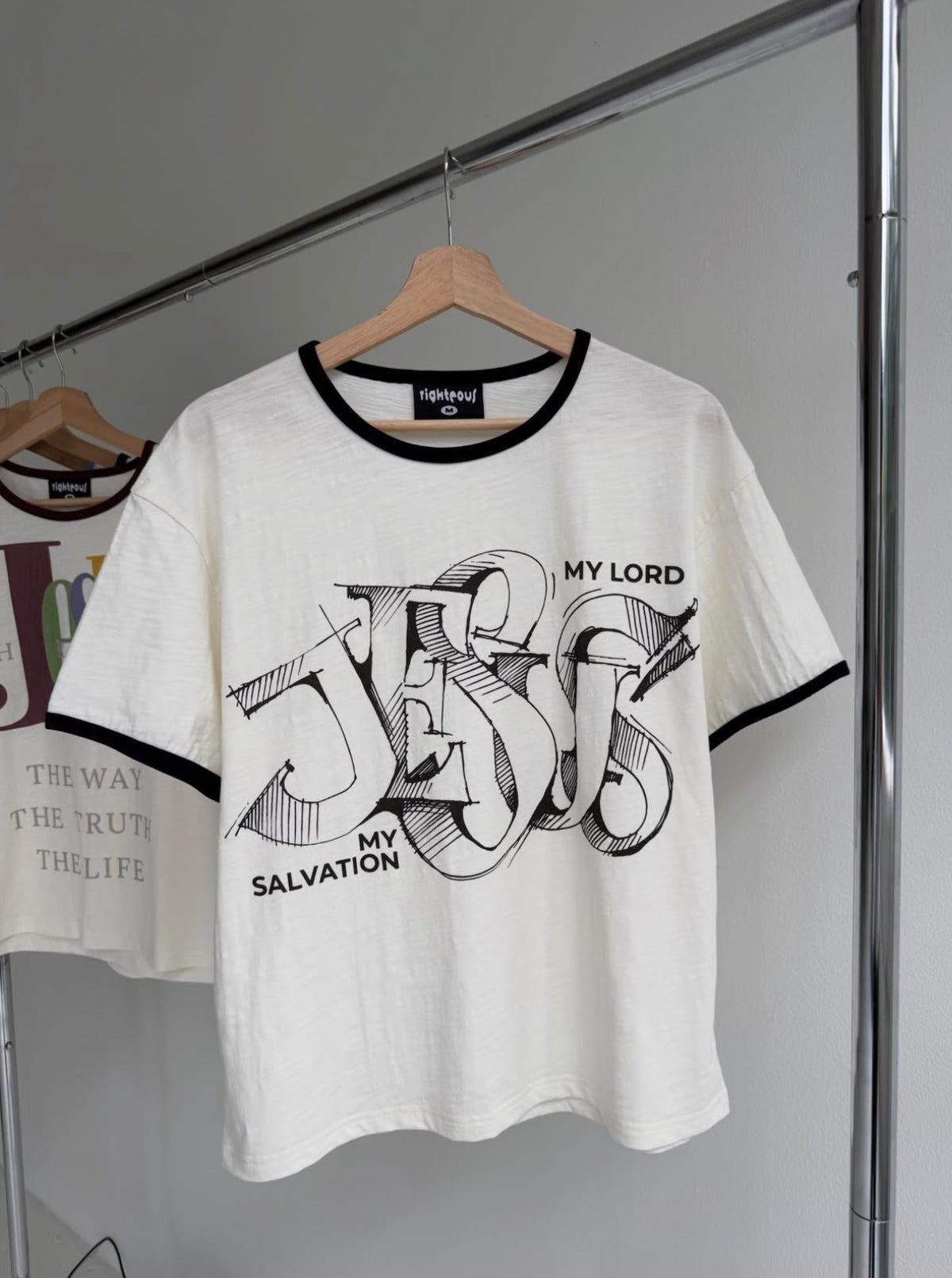 We Are Righteous My Salvation Ringer Tee on a wooden hanger showing the chest graphic