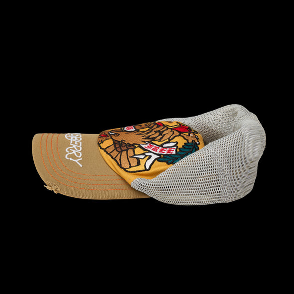 Top-side view of the trucker cap showing cream mesh panels and gold front crown