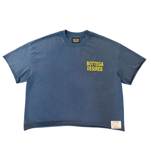 Bottega Desires Blue Fuck Em T-Shirt, boxy washed slate-blue tee with small yellow chest text and a woven label at the hem