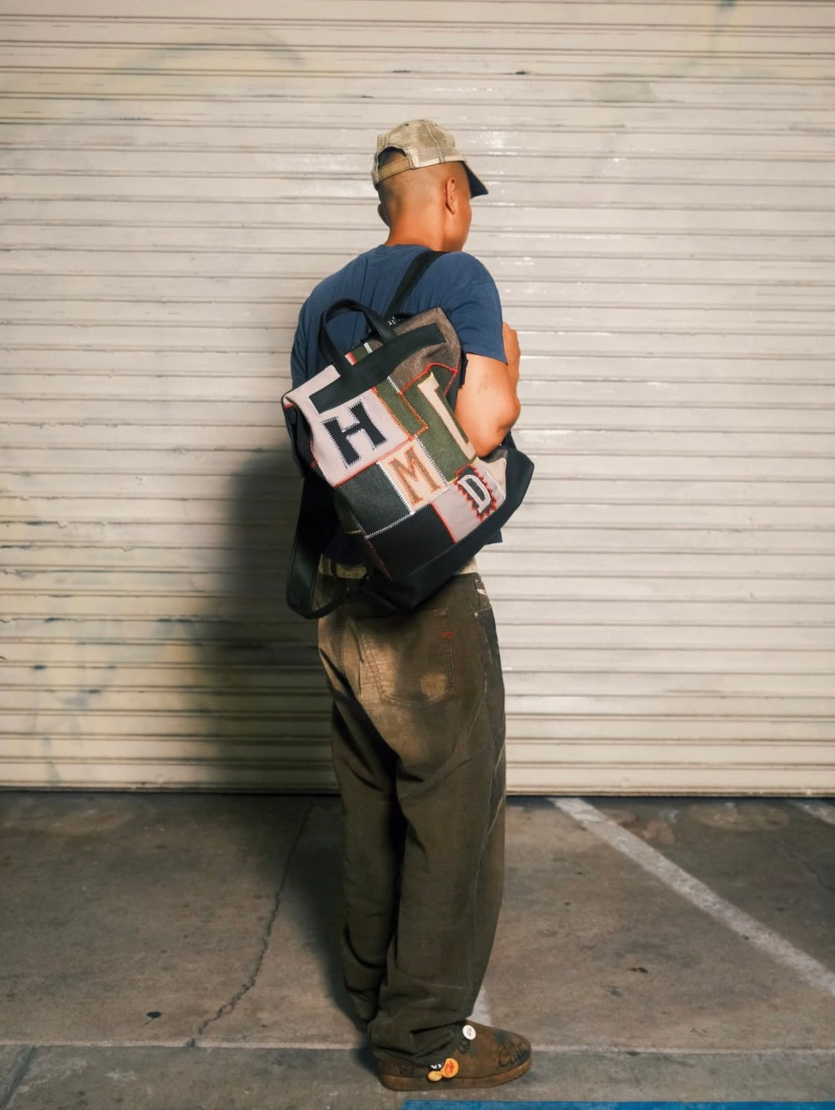 Model photographed from behind wearing the HMDD Hopscotch Backpack on both straps