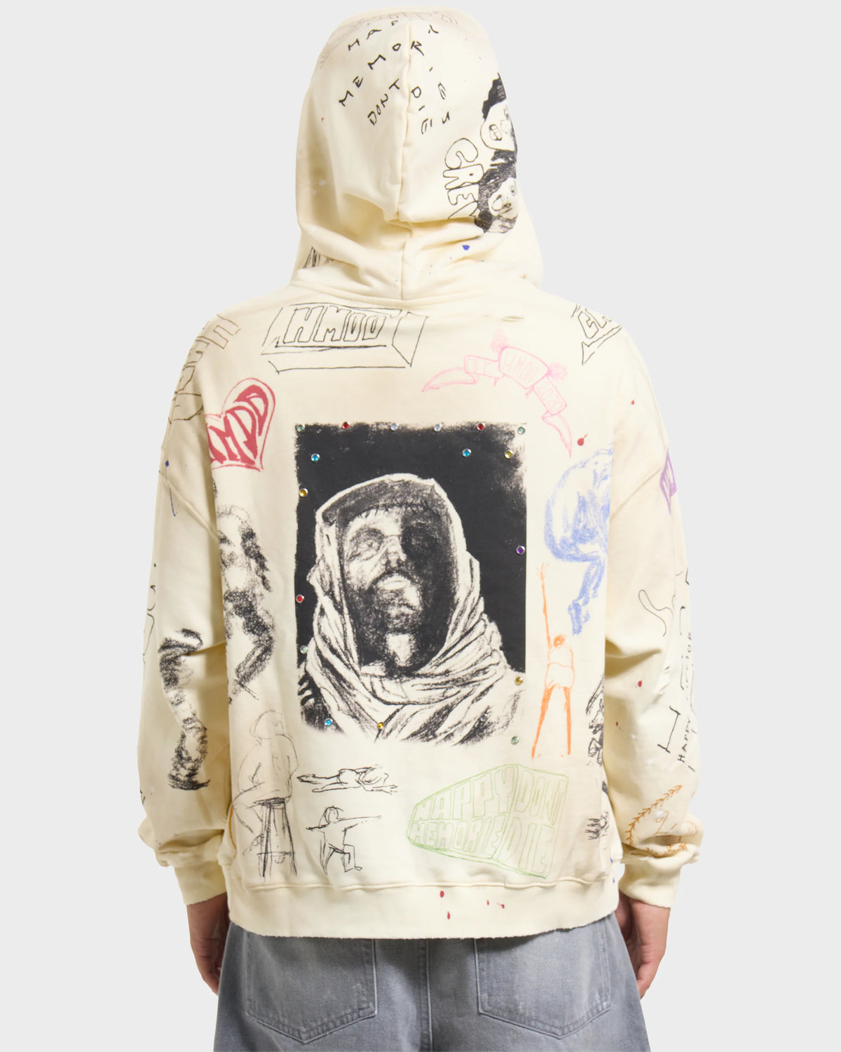 HMDD Sketch Hoodie, back on model showing the framed hooded-figure print and scattered drawings, hood up over grey jeans
