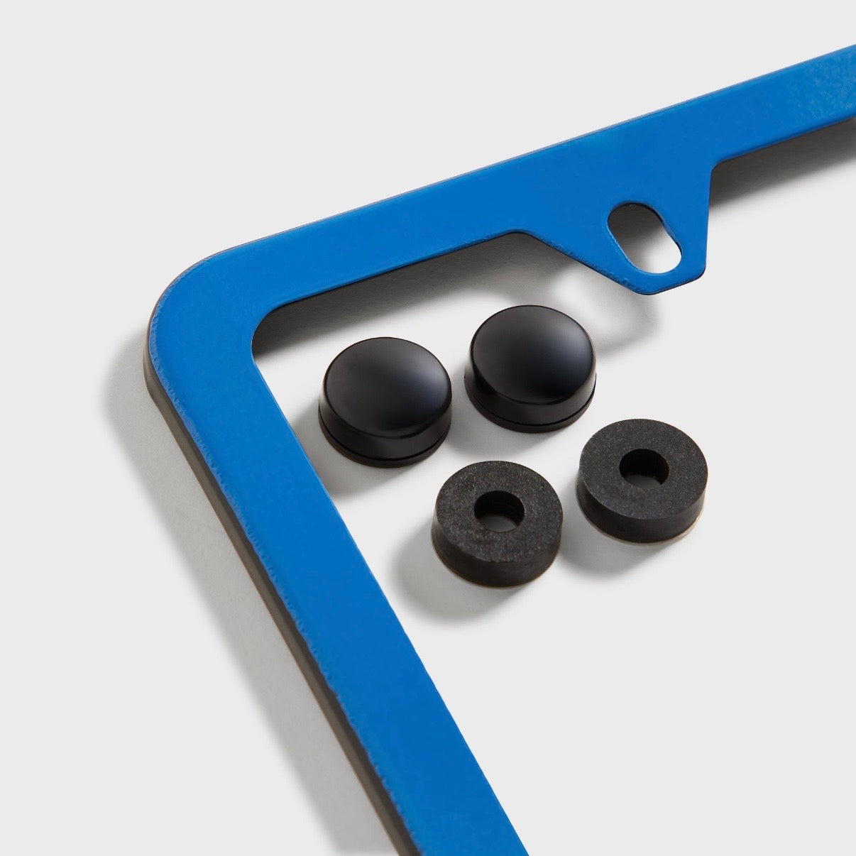 Kith BMW Multi License Plate Holder, angled view of the light blue corner of the frame with four black screw caps