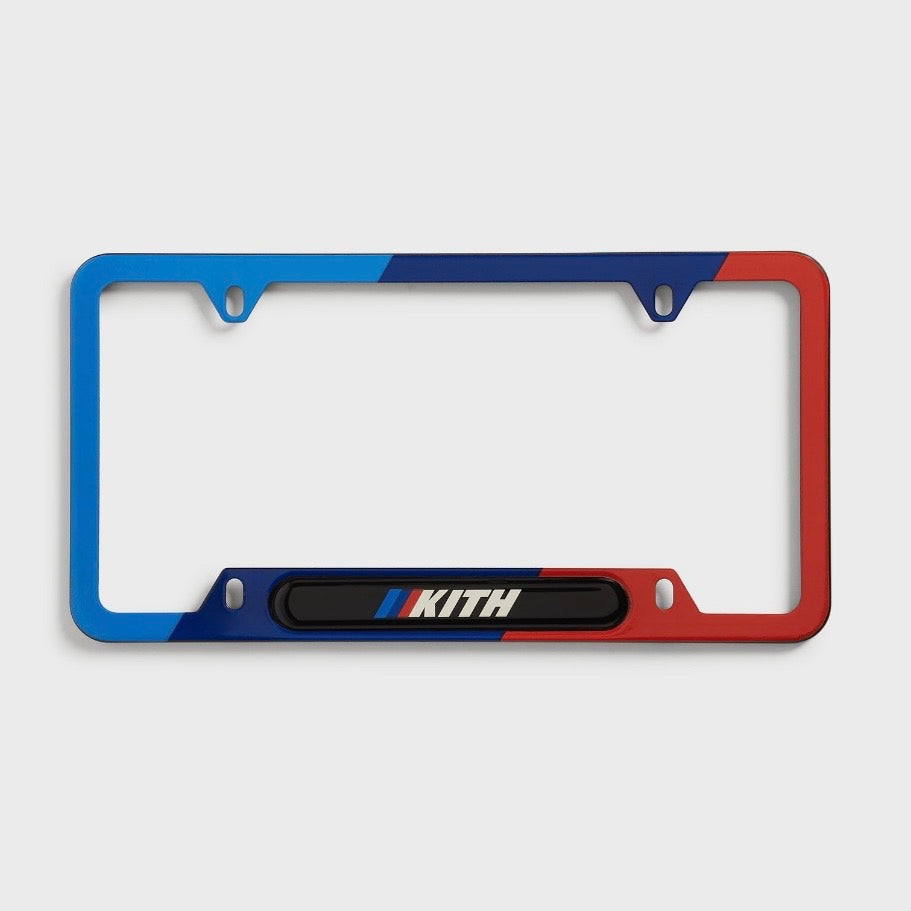 Kith BMW Multi License Plate Holder, front view of the frame in light blue, navy and red with a Kith logo on the lower bar