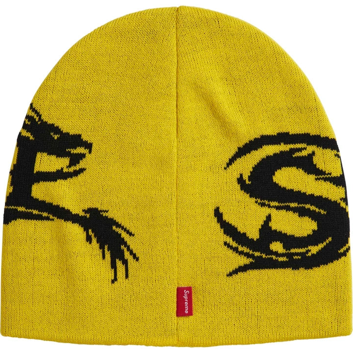 Back of the yellow Supreme Dragon beanie showing the black dragon tail, a large S and a red woven tab