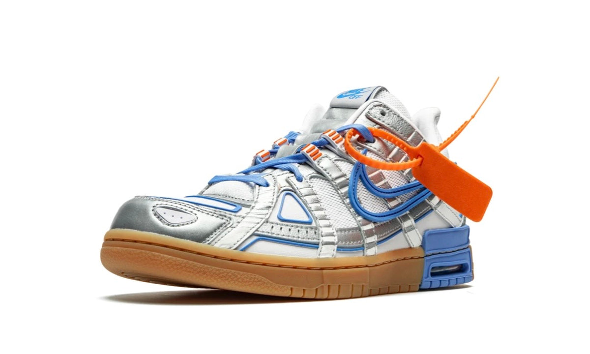 Off-White x Nike Air Rubber Dunk UNC, front three-quarter view with orange zip tie and blue Swoosh