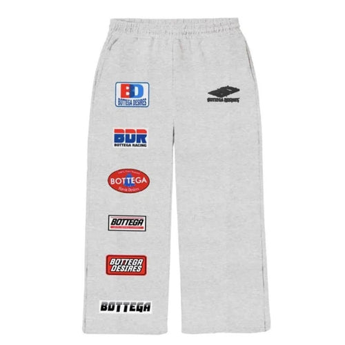 Bottega Desires Grey Patches Sweatpants, grey sweatpants with racing sponsor patches down one leg and a black logo at the hip