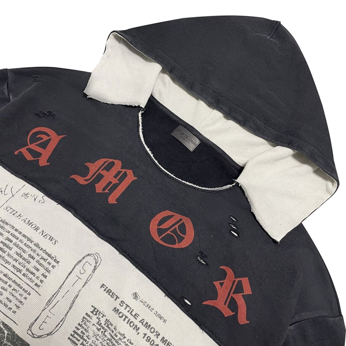 Close-up of the cream hood lining and red AMOR lettering on the Nero Patch Hoodie