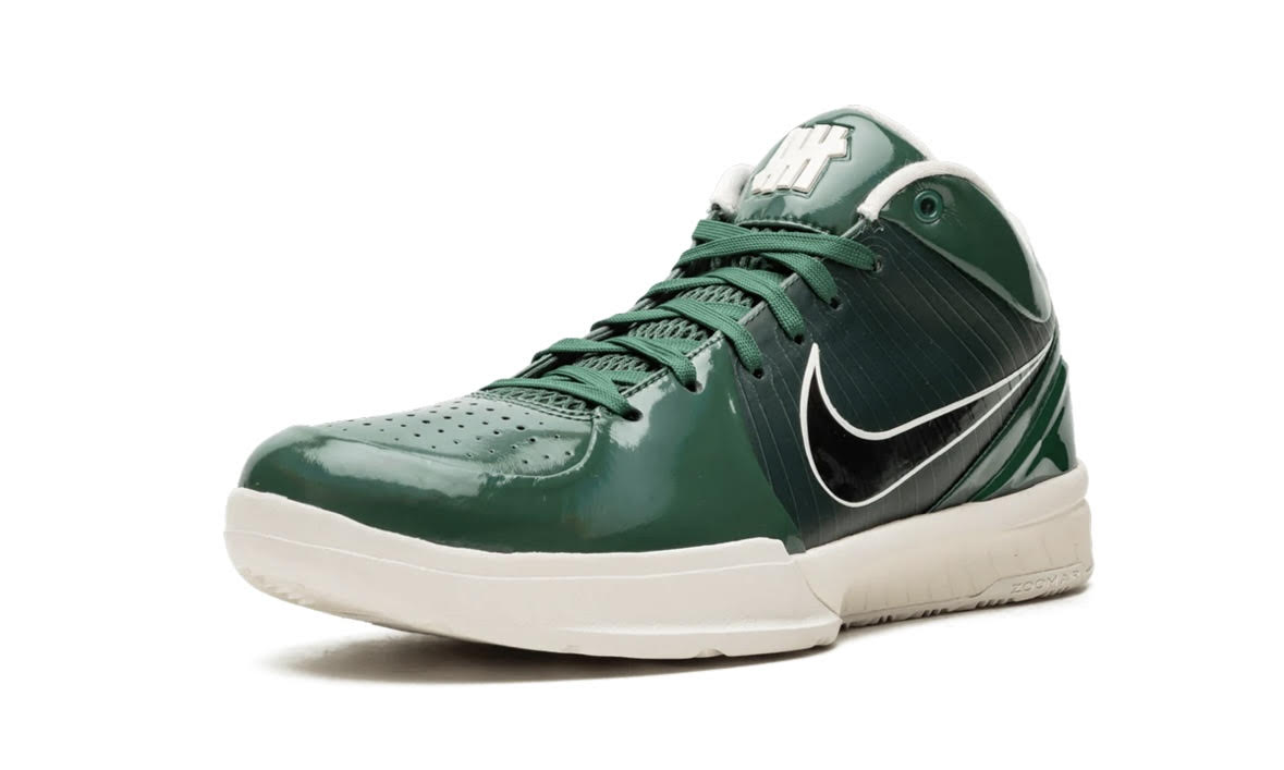 Nike Kobe 4 Protro Undefeated Milwaukee Bucks, angled view of one green shoe with UNDEFEATED tab at the collar