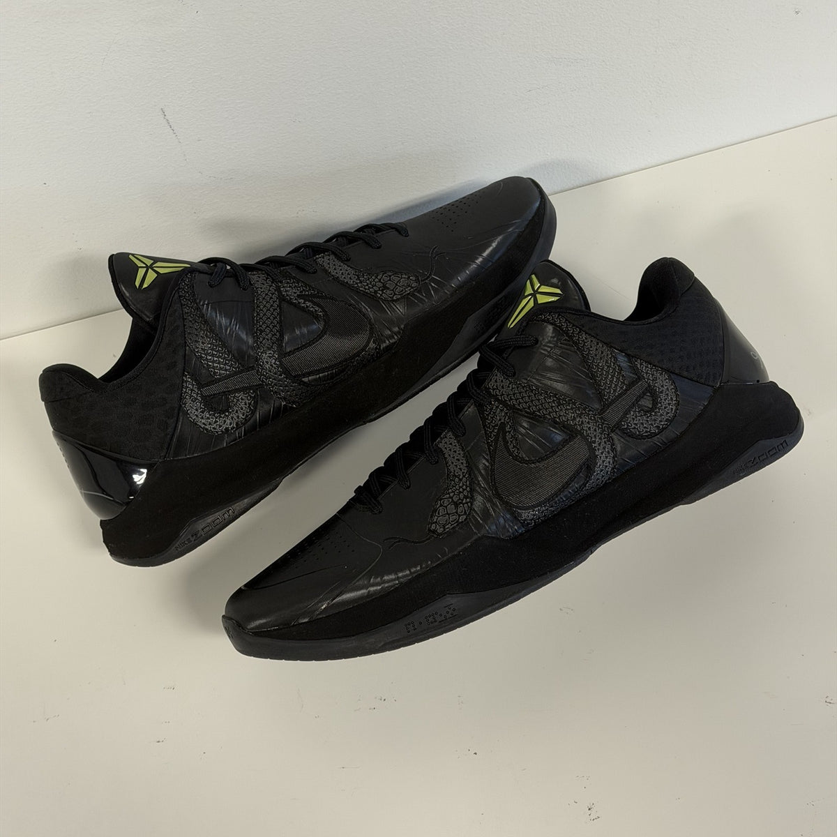 Nike Kobe 5 Protro Year of the Mamba Black, lateral sides of both shoes with textured snake wrapped around the Swoosh