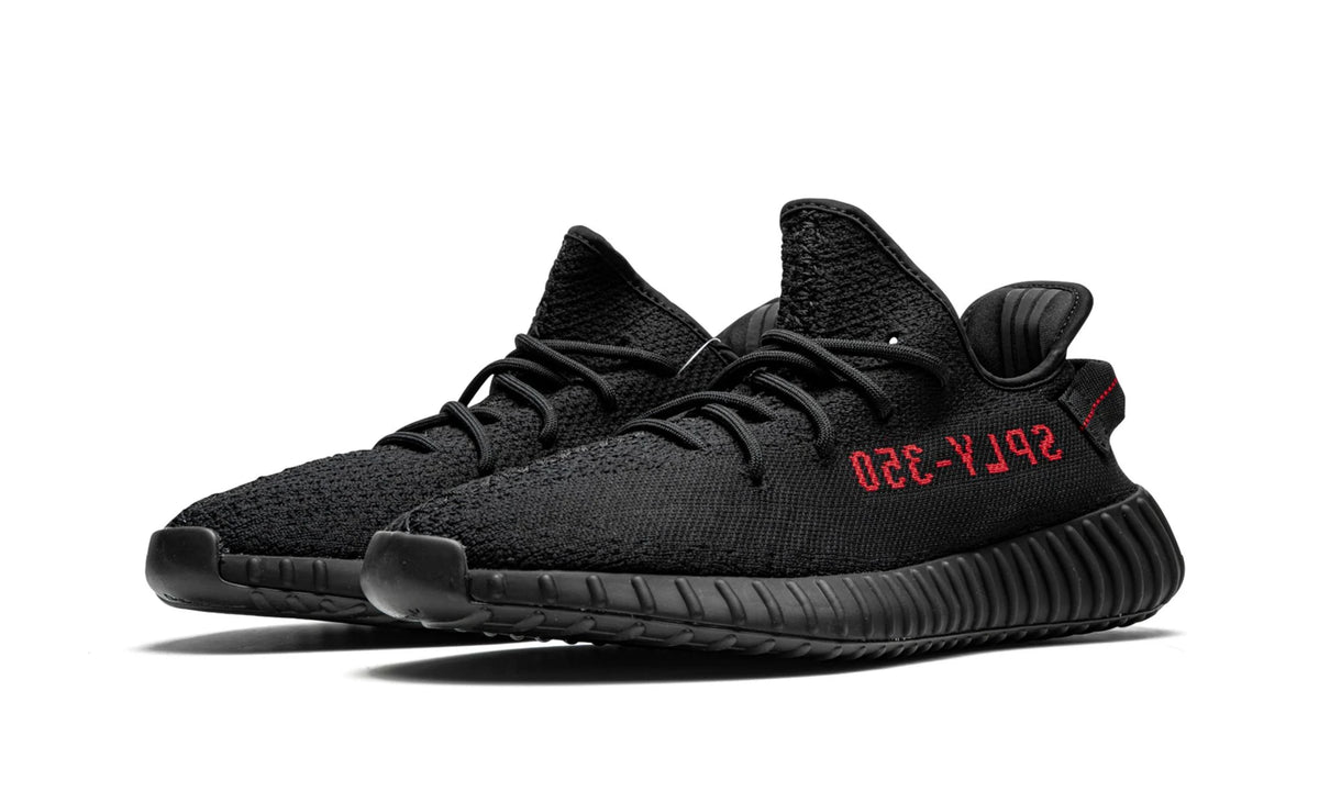 Yeezy 350 V2 Black Red, angled pair shot showing both lateral sides with red side text.