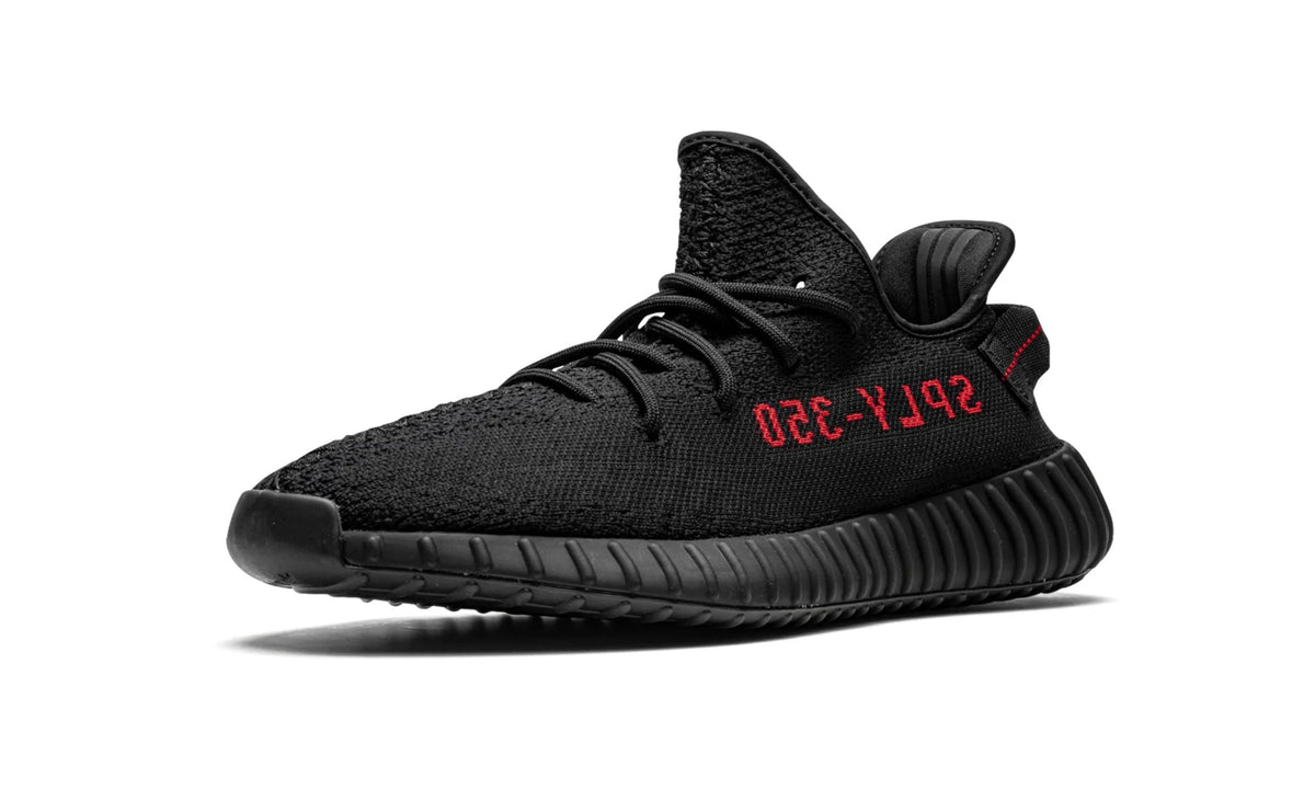 Yeezy 350 V2 Black Red, opposite side profile of the all-black knit shoe with red stripe lettering.